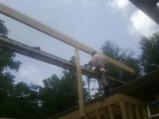 Carpenter setting a ridge beam over a new addition frame — Ice Dam Removal by Roofing Brothers in Hacker Valley