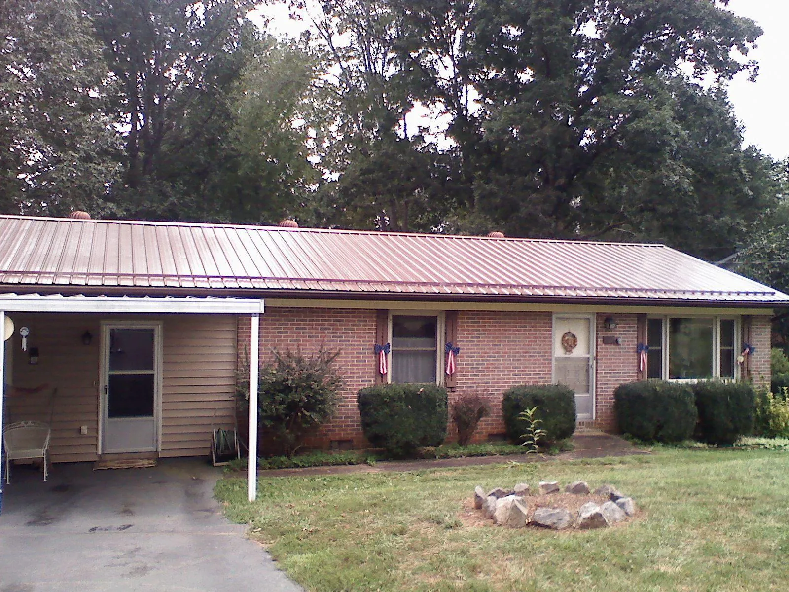 Bronze metal roof and carport on a brick ranch home — Roof Repair work by our crew in Hacker Valley